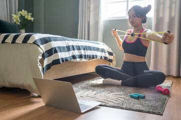 Fit asian woman wearing a spore bra,masks and doing yoga plank a in bedroom at home. New normal and...