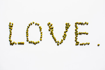 the inscription love is made of mung beans on a white background top view