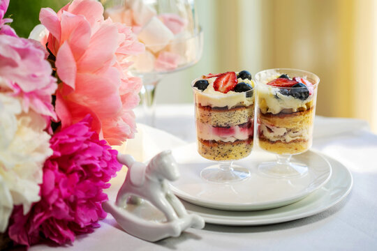 Strawberry cheesecake in glasses with fresh strawberries and cream cheese on wooden background. Healthy homemade dessert.