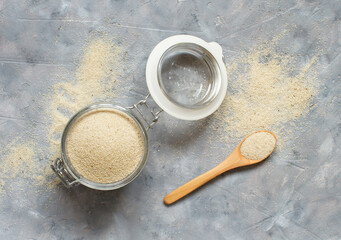 Raw uncooked fonio seeds in a glass jar with a spoon
