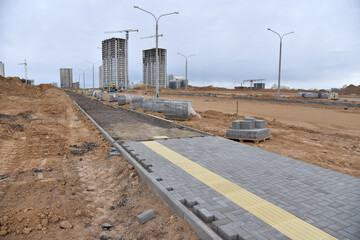 Laying paving slabs at construction site. Process of installing paving bricks in the town...