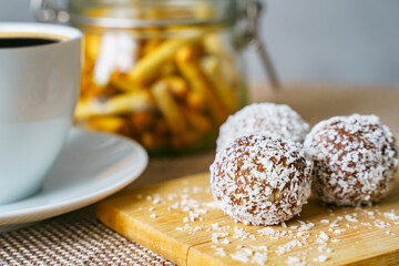 Tasty candies with coconut on a wooden board. Healthy and tasty breakfast
