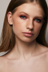 Obraz premium Beautiful face of young woman with clean fresh skin close up isolated on the grey background. Beauty portrait. Perfect fresh skin. Pure beauty model. Youth and skin care concept