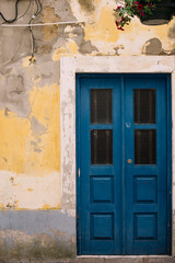 Fototapeta na wymiar Beautiful blue door and old rustic yellow wall, close up view 