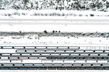 Cargo train terminal, railway hub in winter aerial drone photo