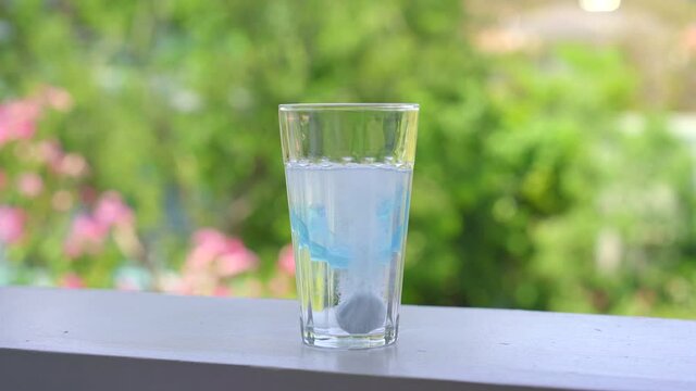 Dental mouthpiece cleaning tablet in a glass