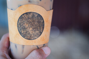 Close-up of a iced coffee cup in a woman hand in the cafe shop.