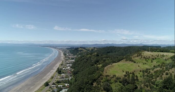 4k aerial right to left panning motion above the popular tourist beach of Ohope Beach, known as one of the top beaches on the North Island of New zealand