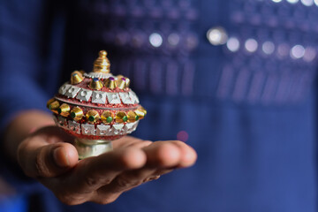 indian traditional vermilion (Sindoor) box in a girl hand with shallow depth of field, Indian...