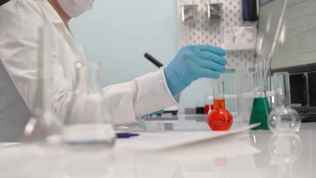 Female scientist get analyzing material on glass plate to plastic box with samples. Science, biotechnology, healthcare and chemistry concept.