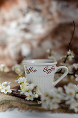 a cup of coffee with flowering tree branches