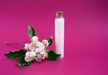 Salt on the pink background. Apple blossoms. Natural cosmetics. Small business. Copy space. Glass jar