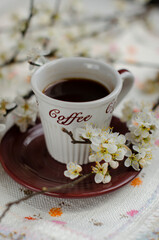 a cup of coffee with flowering tree branches