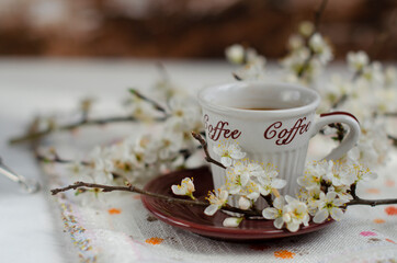 a cup of coffee with flowering tree branches