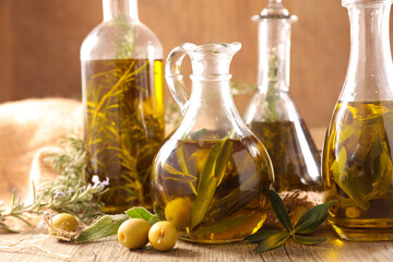 assorted of olive oil in bottle with rosemary