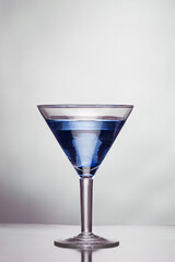 Glass of blue martini on a white background