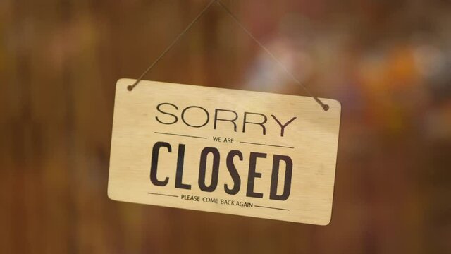 sorry we are closed sign hanging outside a restaurant, store, office or other