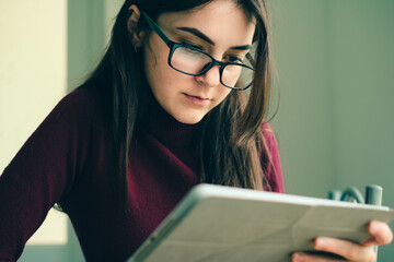 Close up of girl working on tablet from home during period of restrictions.
