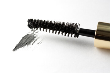 mascara wand with gold colored handle on white background with smear, close up detail shot with macro lens © betzalit