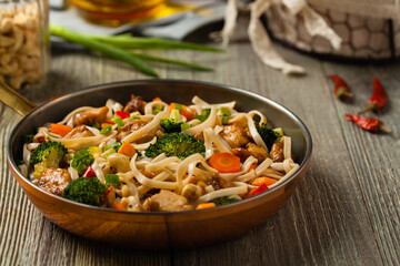 stir-fry pasta with chicken, broccoli and carrots.