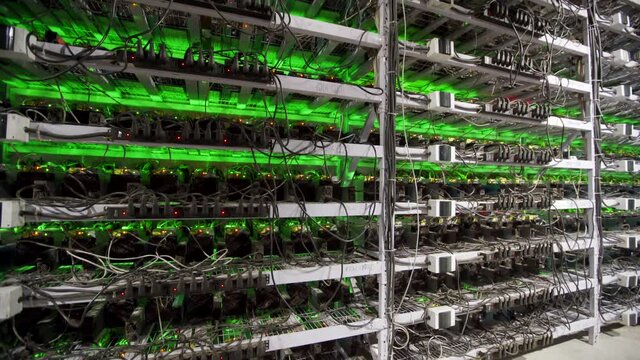 Cryptocurrency mining equipment on large farm. ASIC miners on stand racks mine bitcoin in server room. Blockchain techology application specific integrated circuit. Tripod panorama.