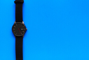 International Father's Day. Men's holiday. Greeting card for dad. Wristwatch on a blue background. Men's Accessories. Place for text. Flat lay. Top view.