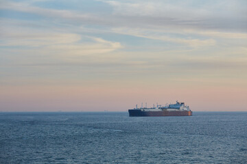 Commercial cargo ship sailing across North Sea in fading dusk light