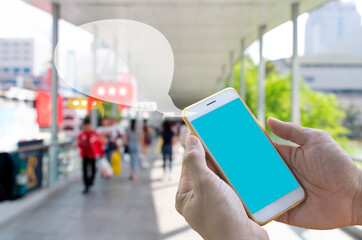 Businessman holding their smartphones with a blue screen and white screen with mock designs and have a bubble message frame for speech and social media or chat communicate from the phone.