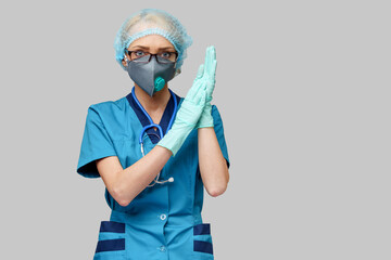 female doctor with stethoscope wearing protective mask and latex gloves over light grey background