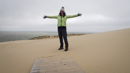 Tourist girl among Curonian Spit sand dunes in Nida, Lithuania
