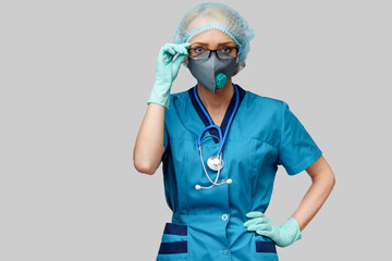 female doctor with stethoscope wearing protective mask and latex gloves over light grey background