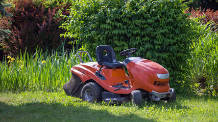 Rasentraktor wartet im Garten auf seinen Einsatz-Konzeptbild Gartenarbeit-Gartenpflege, Gartenservice © Sonja Birkelbach