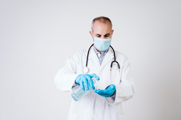 doctor man using alcohol disinfectant gel. using protective mask and gloves during corona virus covid 2019 pandemic. Health care and medical concept