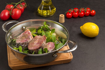 Fresh river fish and mint in pan. Cherry tomatoes, oil and lemon