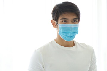 Portrait of a young man wearing a medical mask on white background.