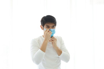 Portrait of a young man wearing a medical mask on white background.