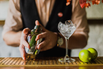 Male bartender holding shaker while making daiquiri cocktail