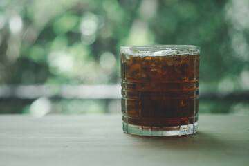 A glass of iced black coffee in glass on the table