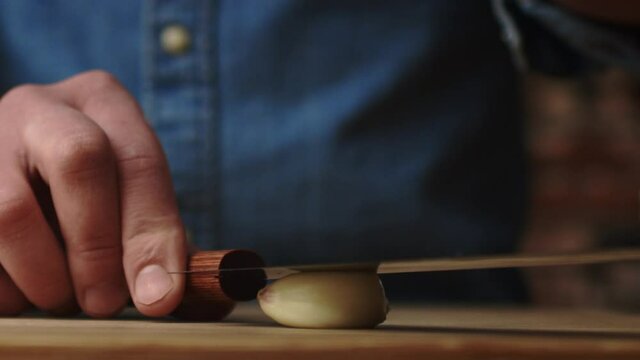 Static video of crushing garlic with a kitchen knife. Shot with RED helium camera in 8K
