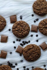 Chocolate and oats Cookies with chocolate chips and chocolate pieces on a white fur background