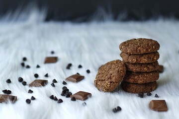 Chocolate and oats Cookies with chocolate chips and chocolate pieces on a white fur background