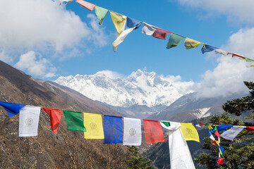 Scenic view of Mount Everest and Lhotse framed by colorful Tibetan Buddhist prayer flags,...