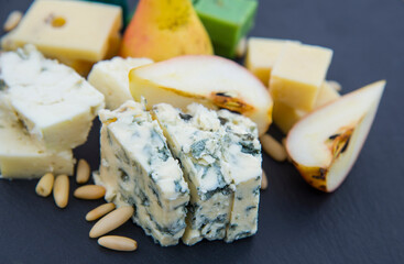 Various types of cheese, pear and pine nuts