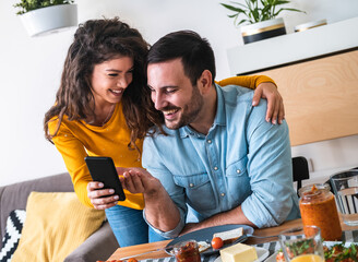 Smiling couple looking in mobile phone excited stock photo
