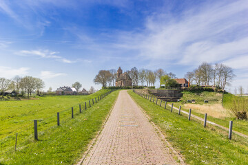 Cobblestoned road leading to the historic church of Hegebeintum, Netherlands