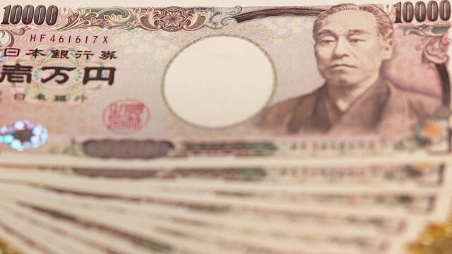 tokyo, japan - may 26 2020: Close-up rack focus video of 100,000 yen in cash sent by the Japanese govt of Abe Shinzo to fight economic unemployment crisis caused by COVID-19 on a golden background.