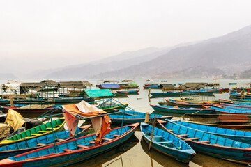 Fototapeta na wymiar Colorful wooden boats in Phewa Lake, Pokhara, Nepal