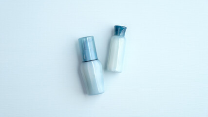 Blue cosmetic bottles with water based natural SPA lotion. Hyaluronic acid collagen beauty products. Flat lay, top view.
