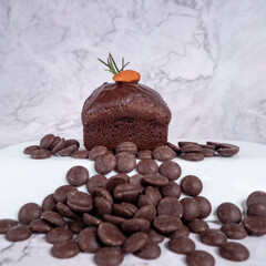 chocolate cake with almond on top placed on white background.