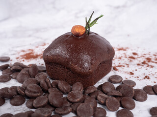 chocolate cake with almond on top placed on white background.